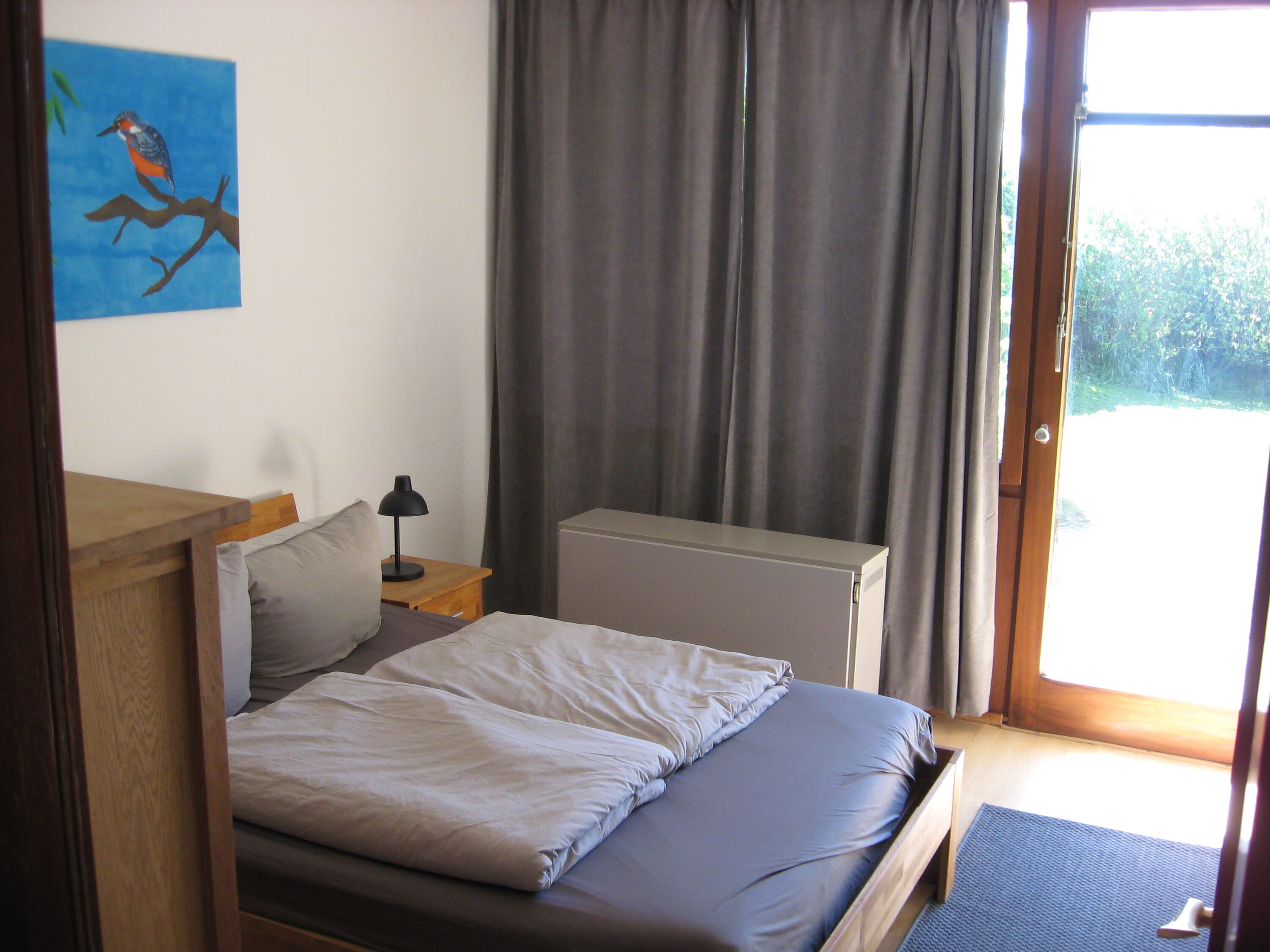 Das kleinere Schlafzimmer mit 140er Bett und direkten Zugang zum Grundstück