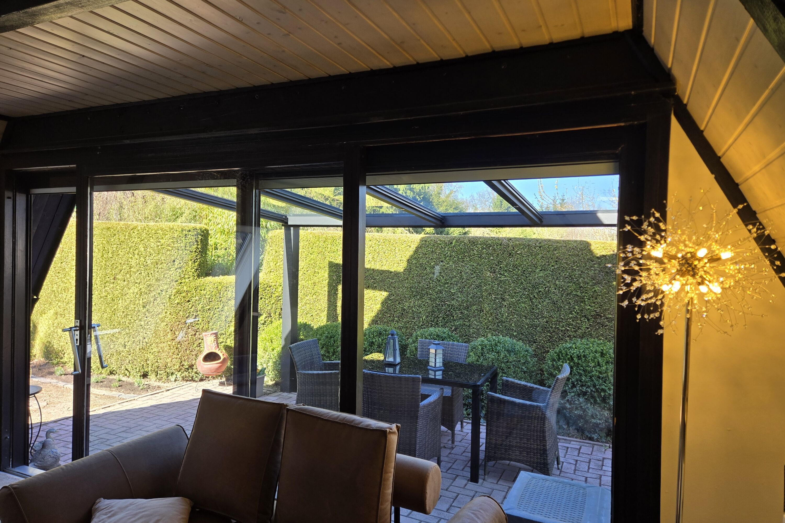 Blick aus dem gemütlichen Wohnzimmer auf die Terrasse mit Terrassendach