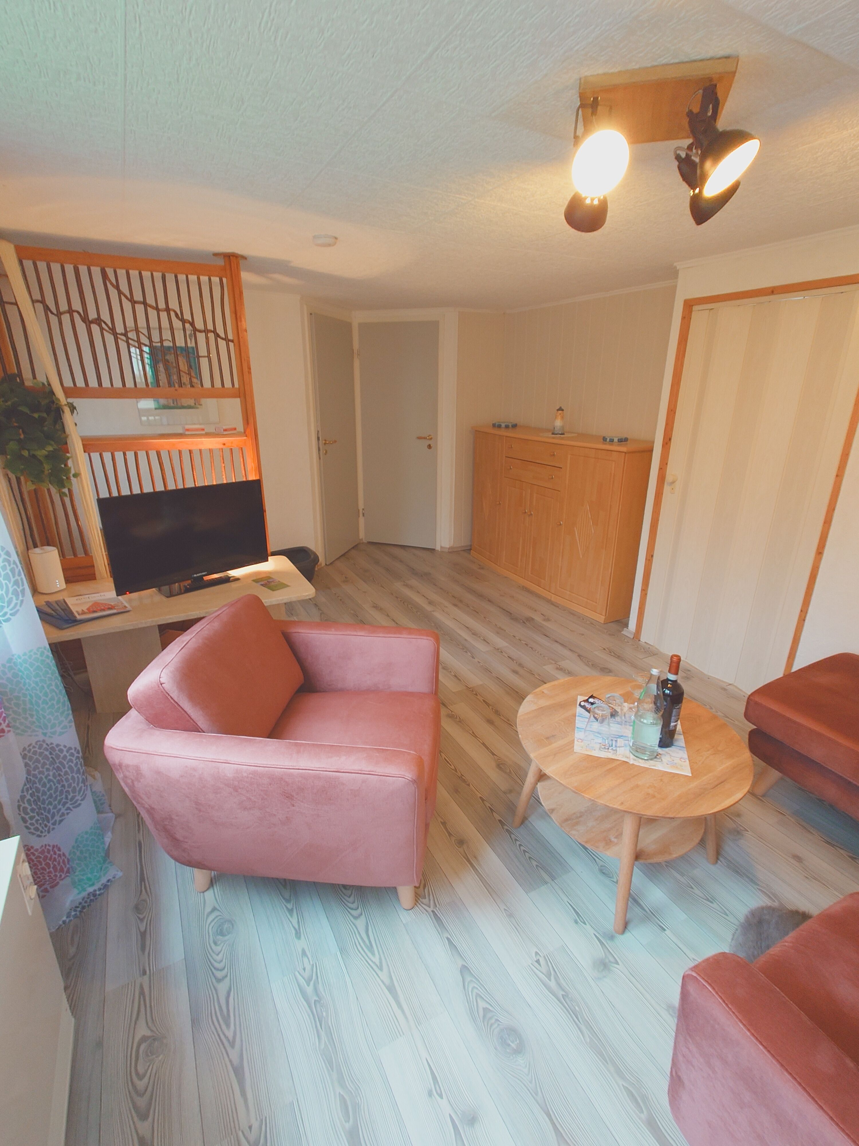 Wohnzimmer mit Blick auf die Eingänge zu den Schlafräumen und der Küche