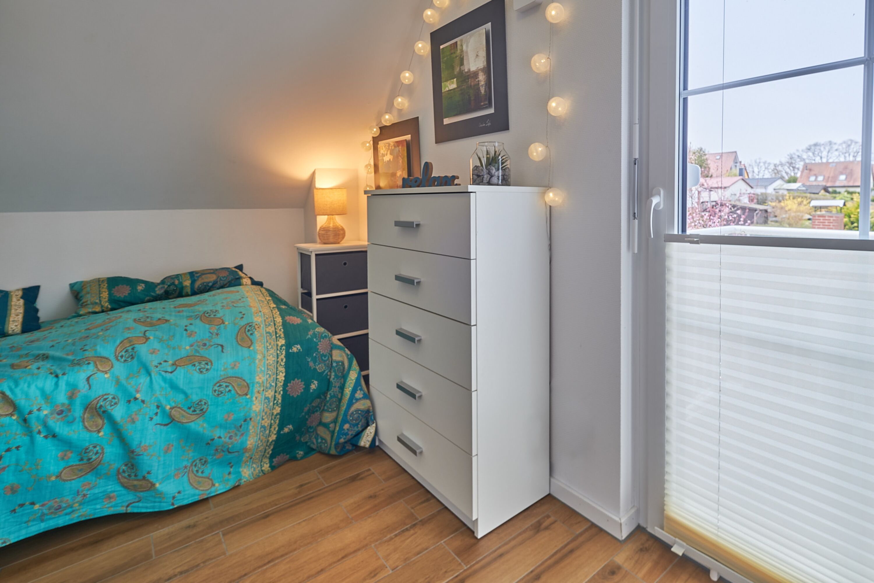 Schlafzimmer mit Einzelbett und Kommode sowie Infrarotsauna