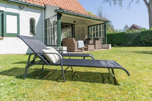 Die überdachte Terrasse mit Gartenmöbel und Sonnenliegen