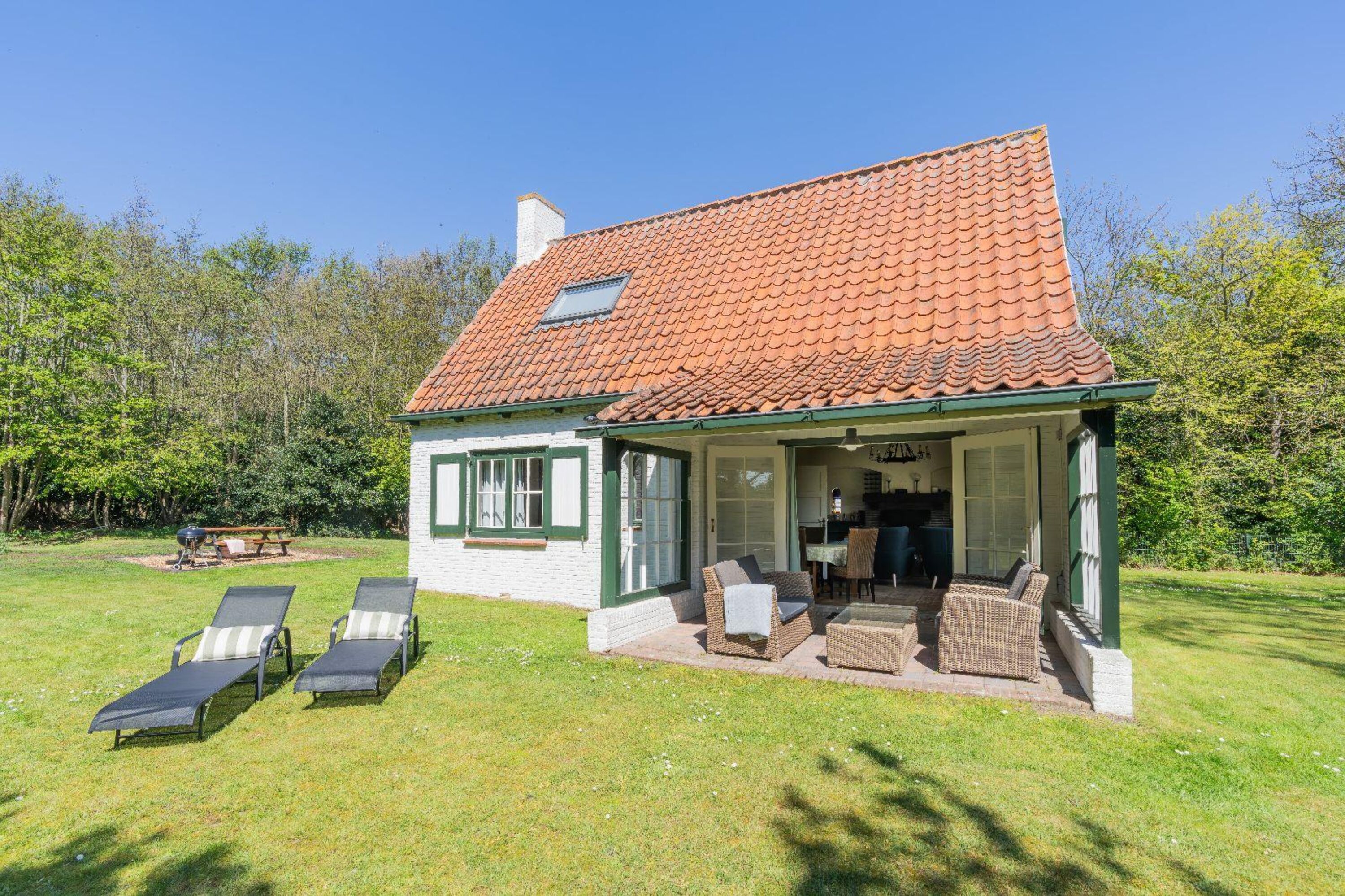 Die überdachte Terrasse mit Gartenmöbel und Sonnenliegen