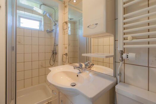Badezimmer mit Dusche, Waschbecken und WC