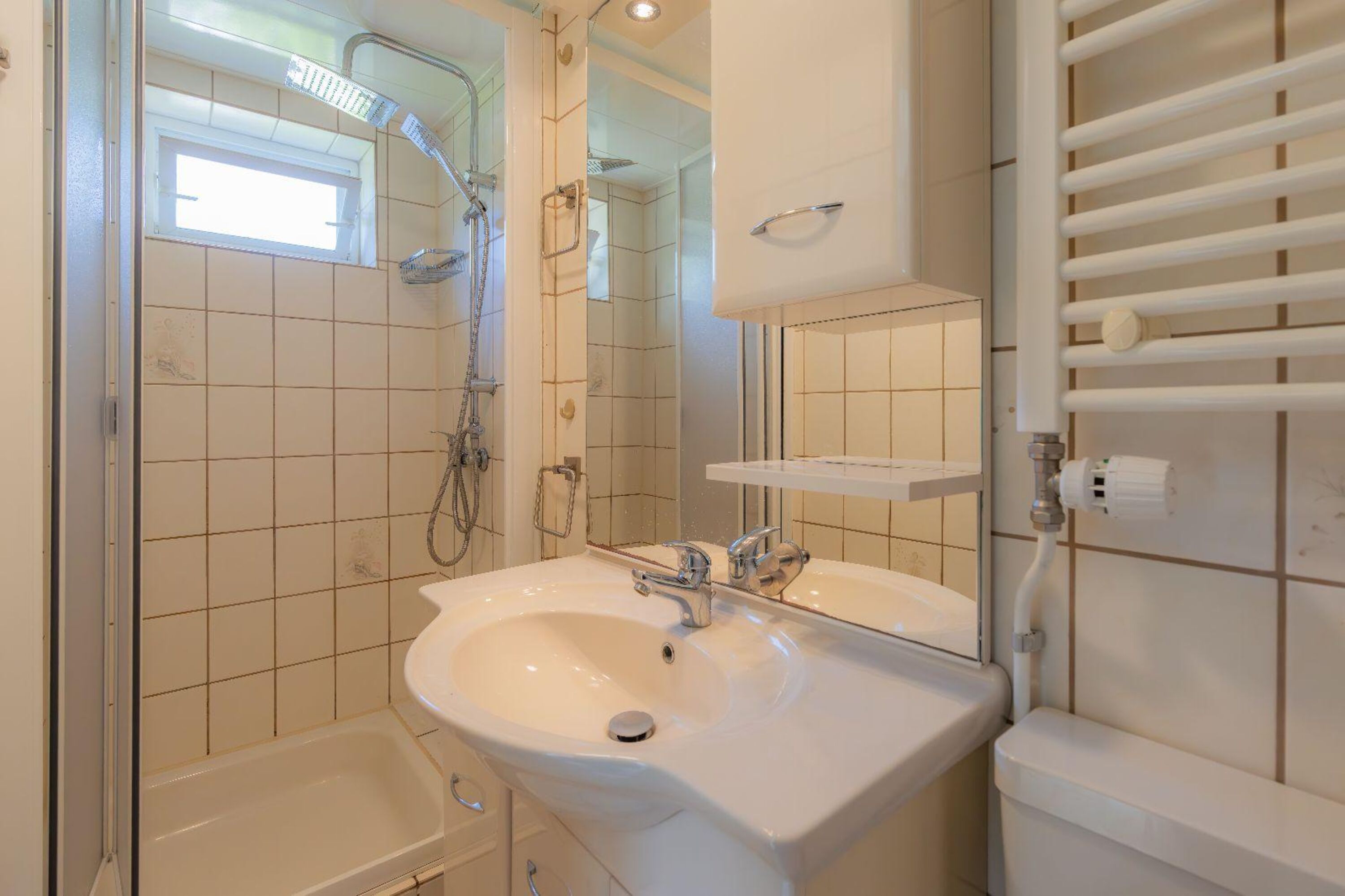 Badezimmer mit Dusche, Waschbecken und WC