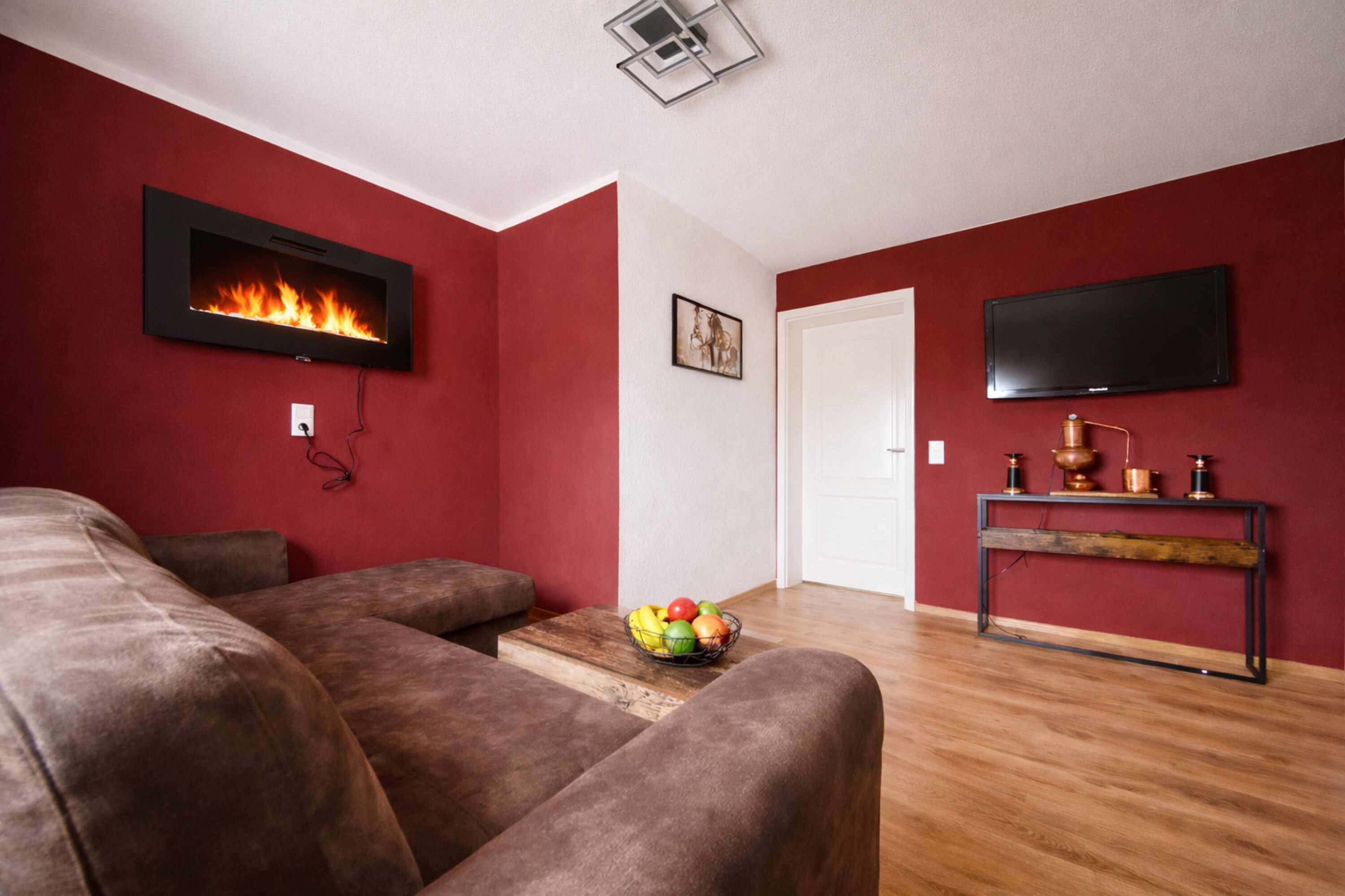 Wohnzimmer mit Elektrokamin und Schlafcouch