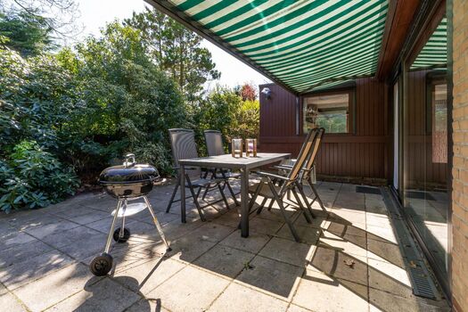Sonnige Terrasse mit Gartengruppe, Markise und Grill