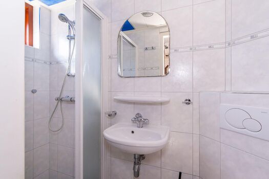 Badezimmer mit Dusche, Waschbecken und Toilette