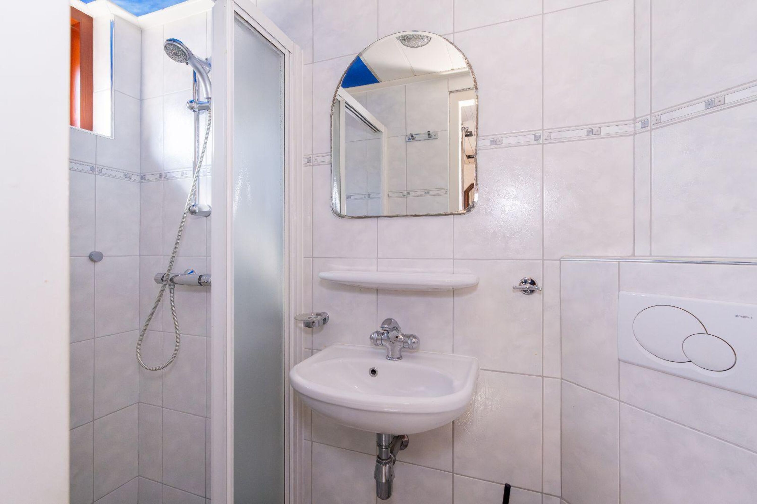 Badezimmer mit Dusche, Waschbecken und Toilette