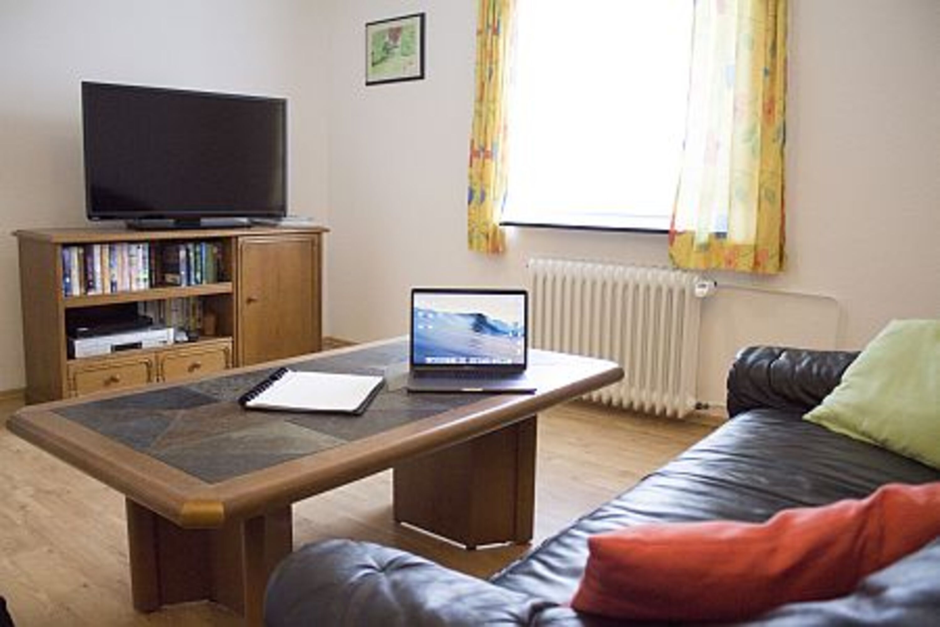 Das Wohnzimmer, mit Coachgarnitur aus Leder, verfügt über einen Flachbildfernseher mit Sat-Anschluß sowie Player für Blu-Ray und DVD.