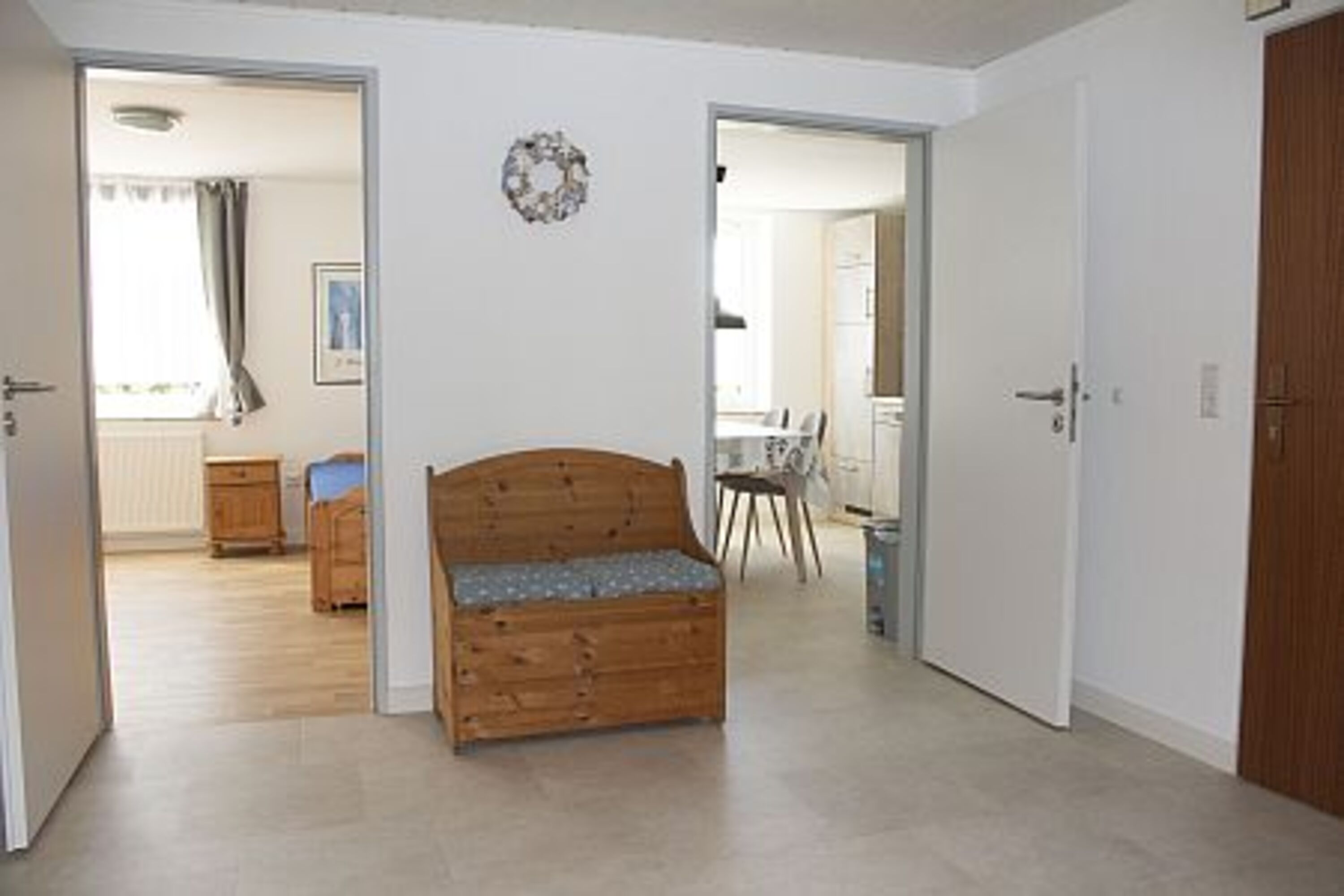Blick aus dem zentralen Flur, der Eingang, Küche, Bad, Wohnzimmer und großes Schlafzimmer verbindet, in die Küche und das zusätzliche Einzelbett im großen Schlafzimmer