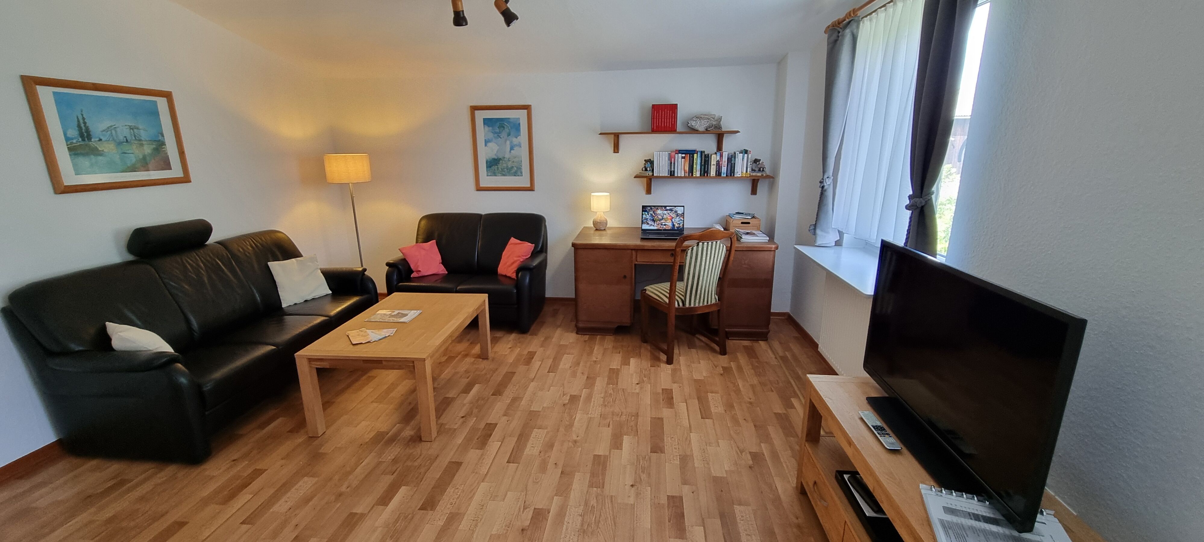 Wohnzimmer mit Schreibtisch und TV