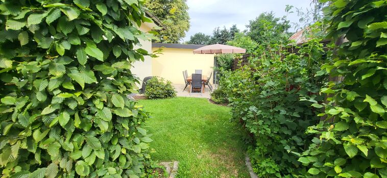 Blick auf die Terrasse mit großem Tisch für 8 Personen