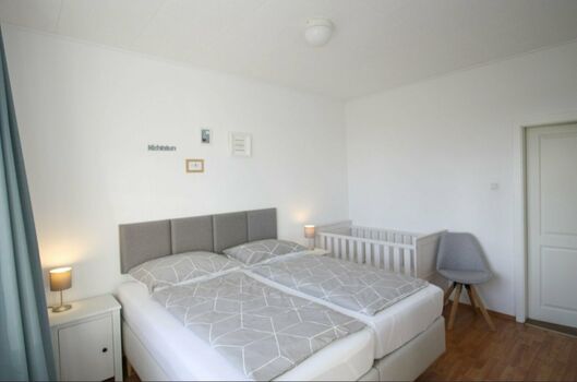 Schlafzimmer 2 mit Doppel-Boxspringbett, Kinderbett und TV