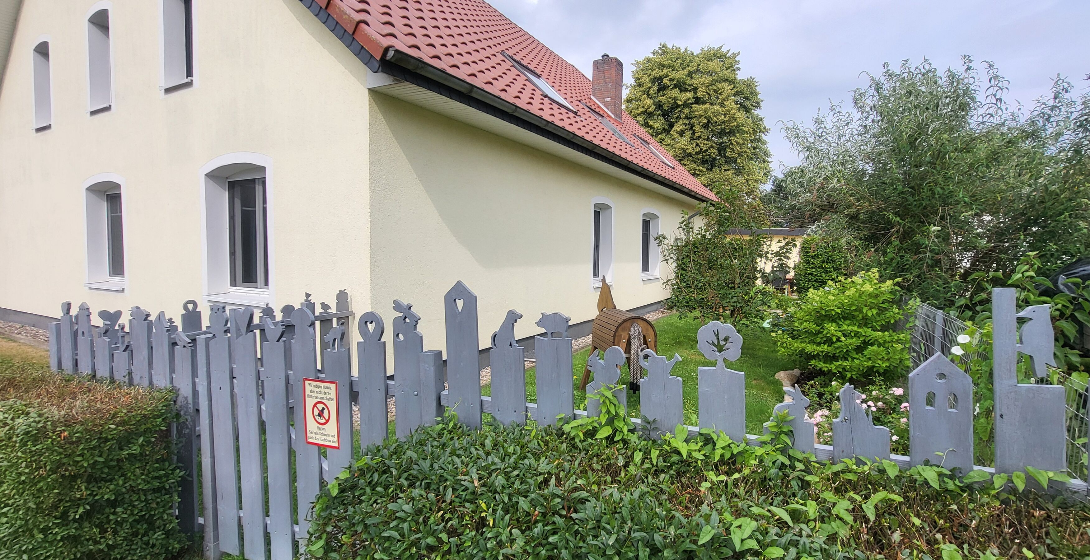 Eingezäunter Gartenbereich mit Terrasse, Sandkasten, Holzpferden