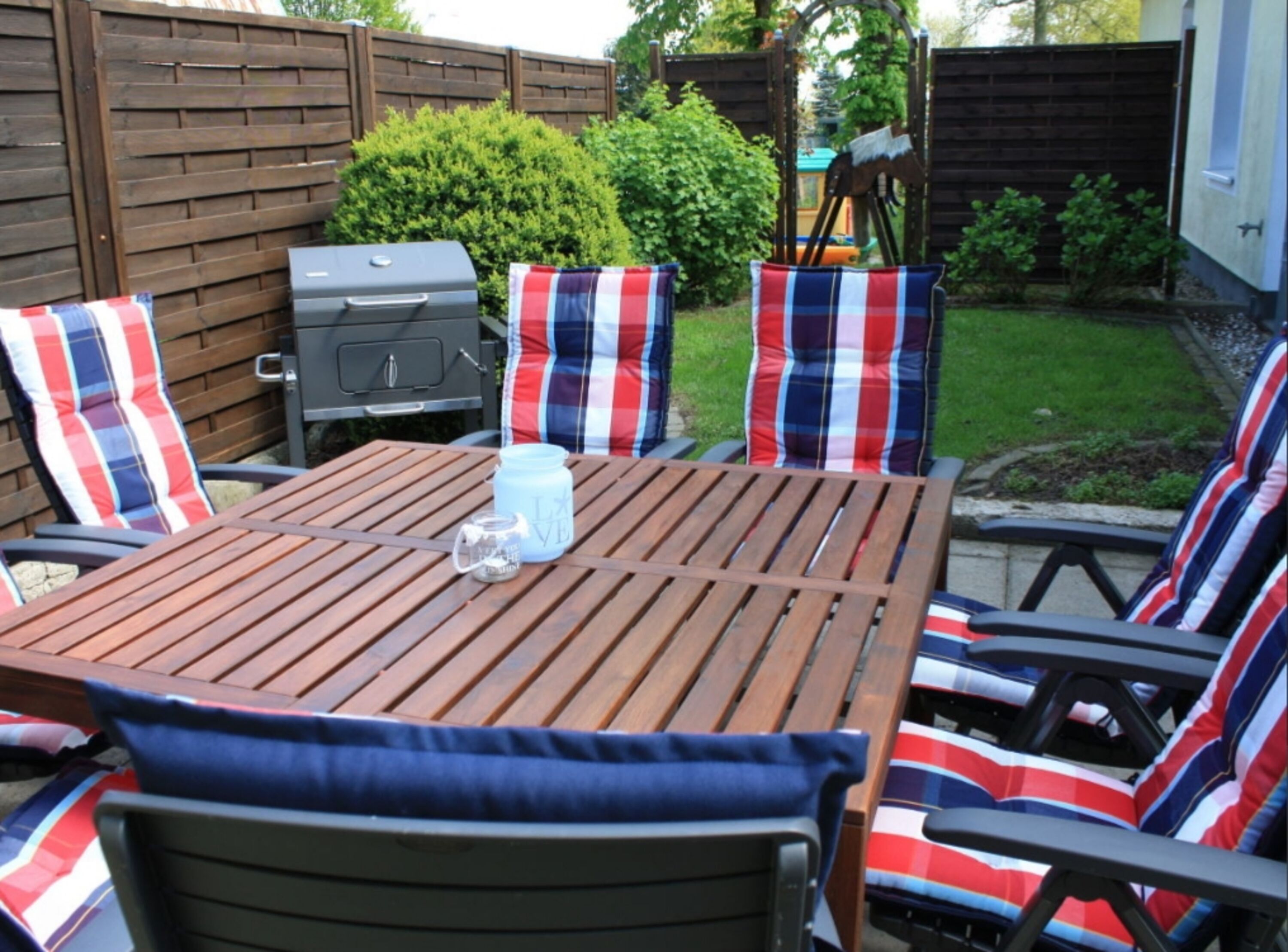 Terrasse mit großem Tisch und bequemen Stühlen