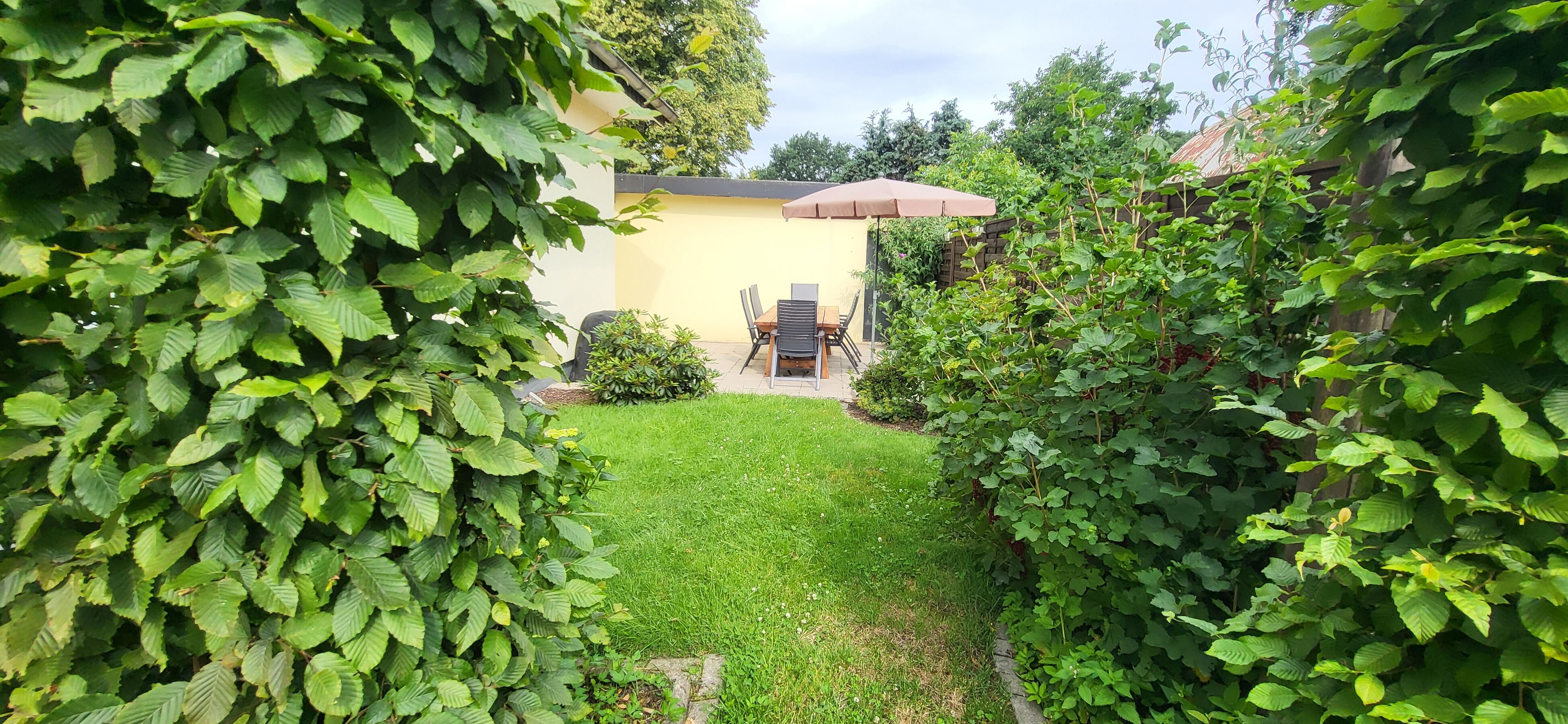 Blick auf die Terrasse mit großem Tisch für 8 Personen