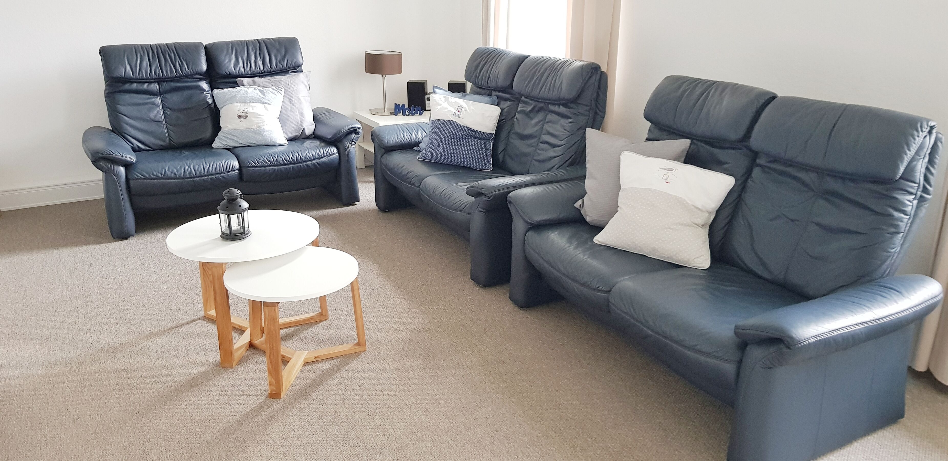 Wohnzimmer mit 3 Sofas, 2 Sesseln, Elektrkamin in Smart-TV