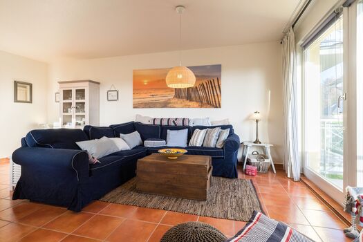 Wohnzimmer mit offener Küche und Zugang zum Balkon