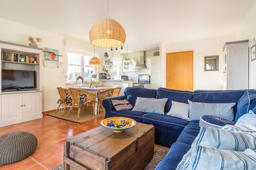Wohnzimmer mit offener Küche und Zugang zum Balkon