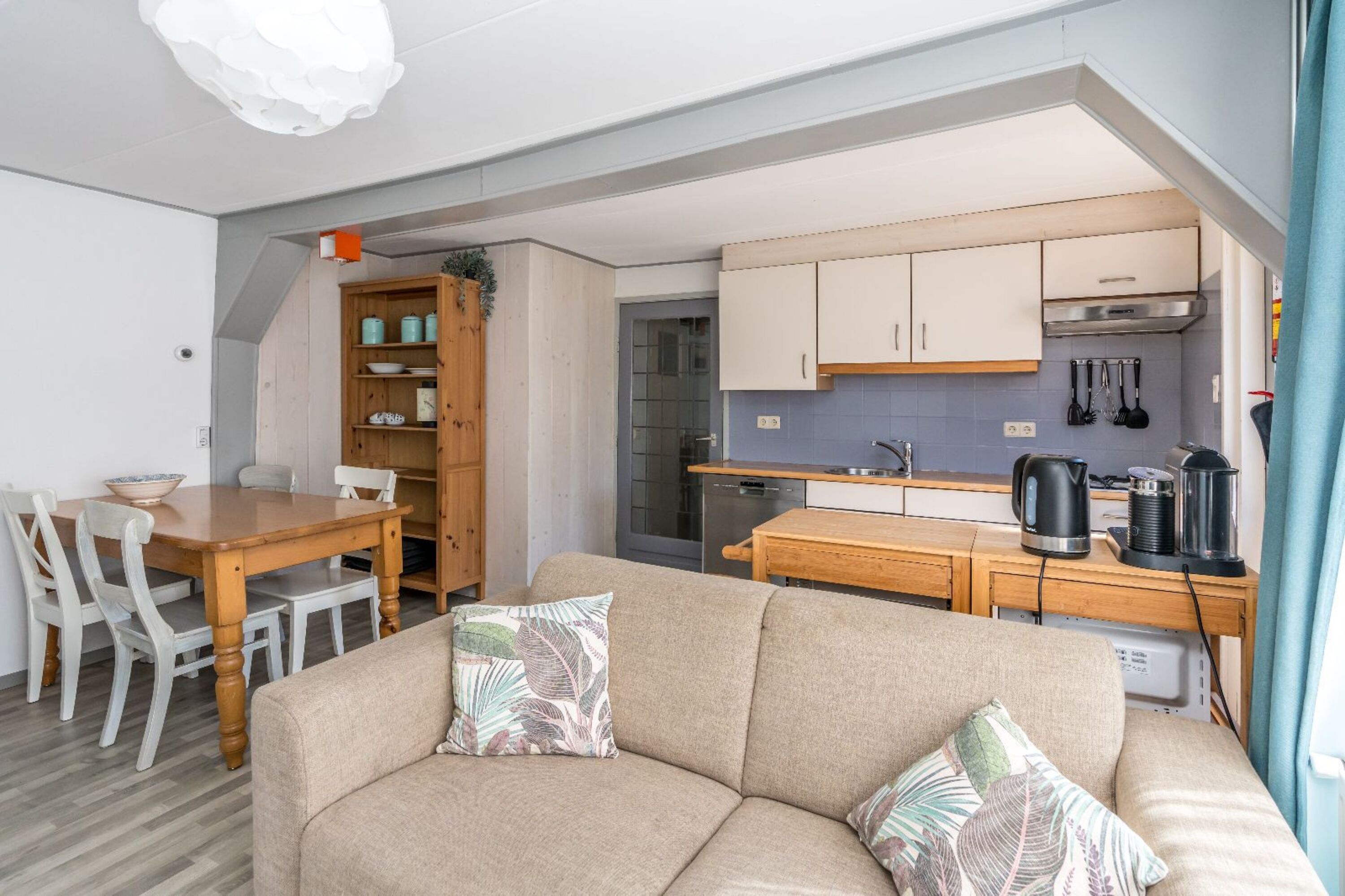 Wohnzimmer mit Esstisch, Sofa und offener Küche