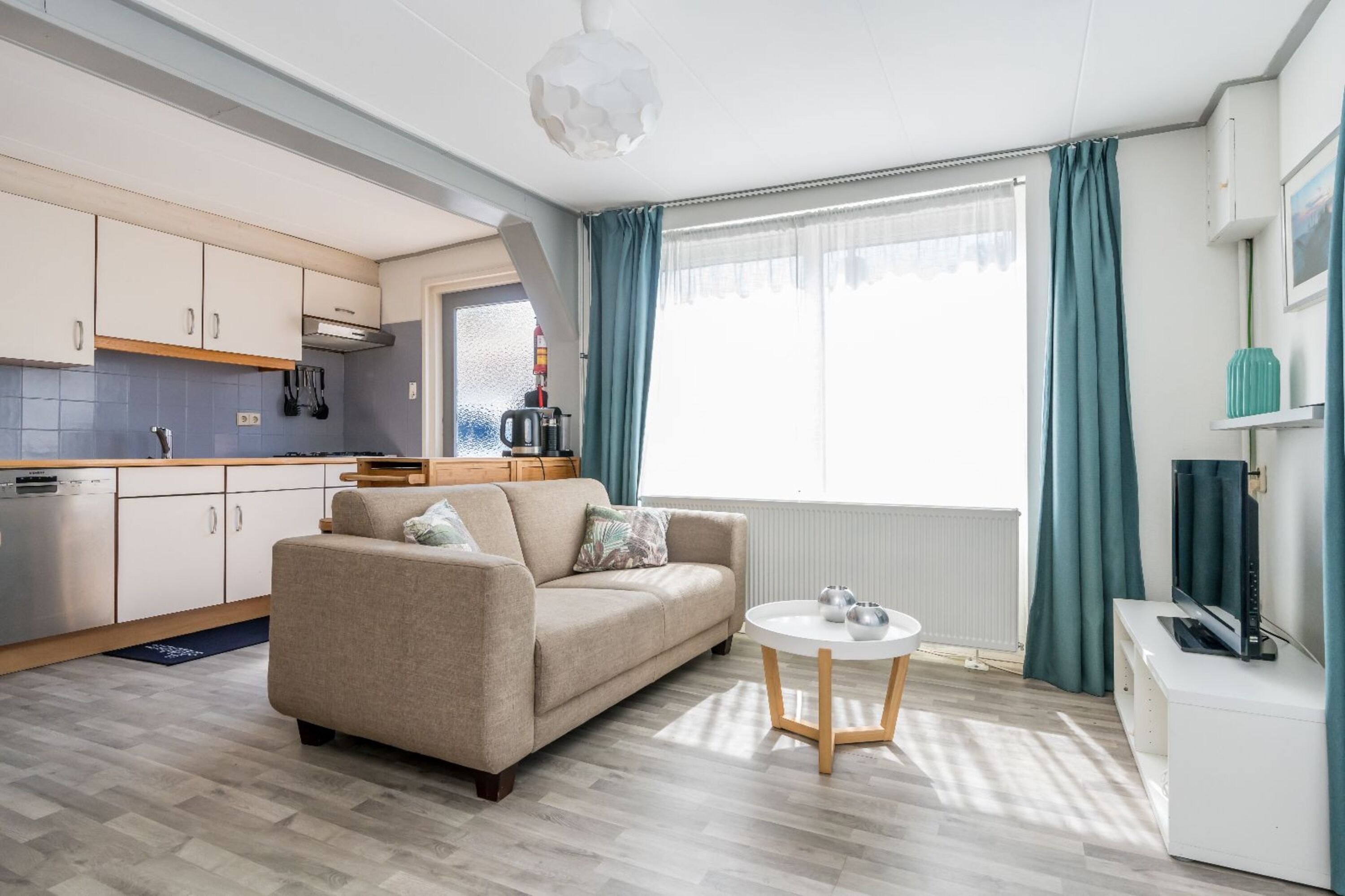 Das gemütliche Wohnzimmer mit Sofa und Fernseher