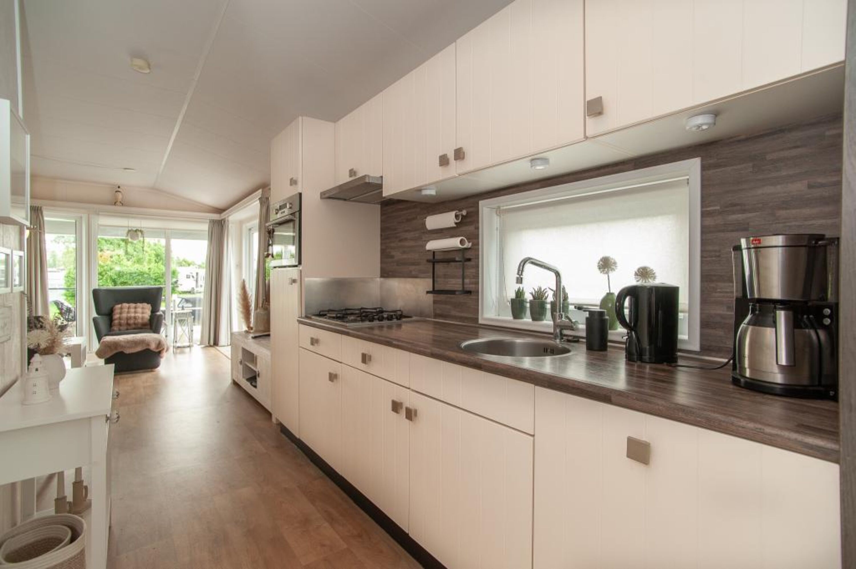 Moderne Küche mit eleganter Holzoptik und stilvollen Geräten.