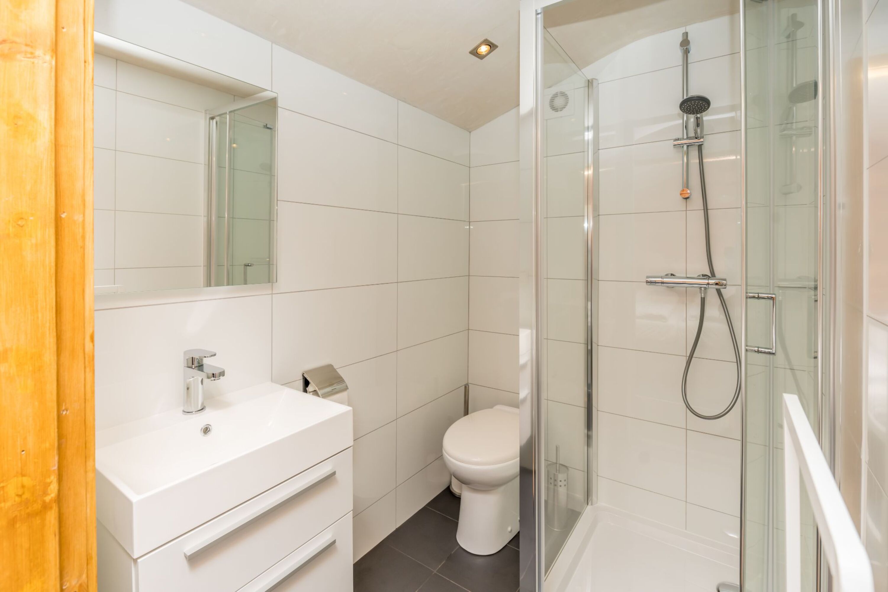 Badezimmer 1 mit Dusche, Badmöbel und Toilette