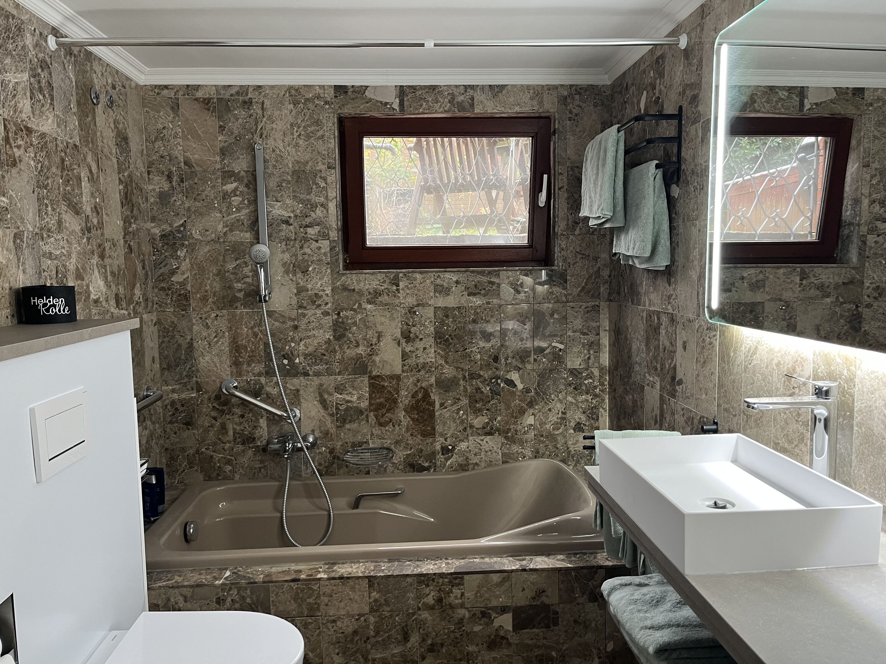 Badezimmer mit Badewanne und Handtuchheizkörper