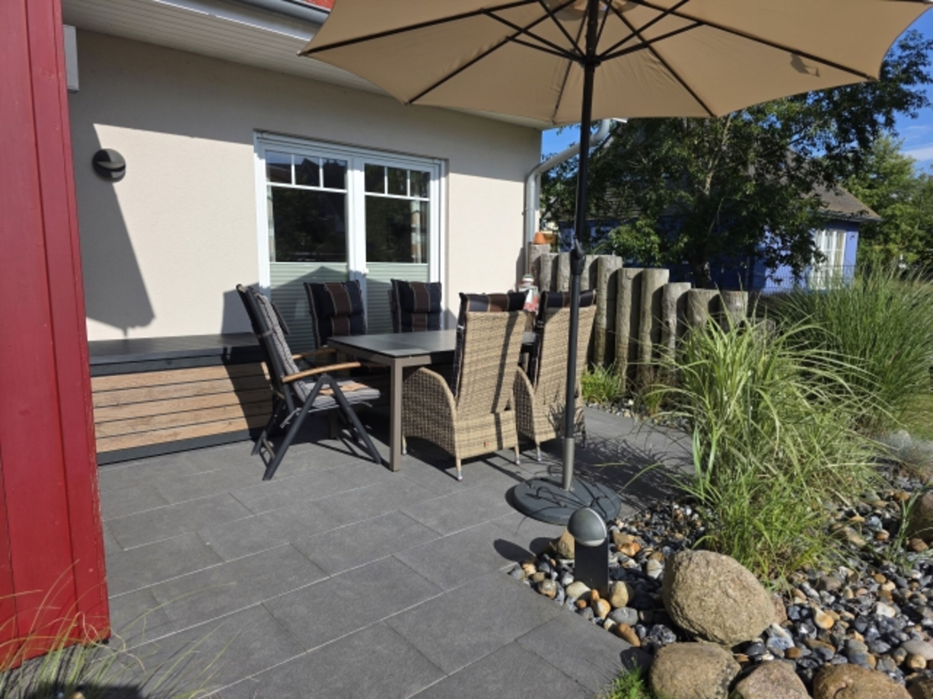 Terrasse mit Sonnenschirm und Grill