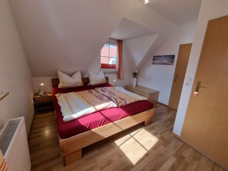 Schlafzimmer mit Doppelbett und Umkleideraum