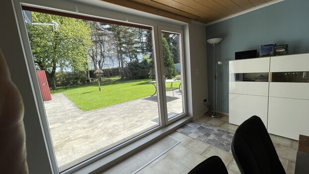 Vom Tisch guckt man in den umzäunten Garten