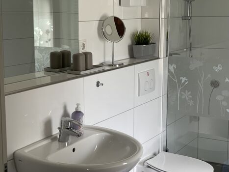 Das Bad ist modern mit bodengleicher Dusche