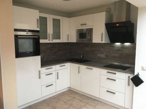 Küche mit Induktionsherd, Geschirrspüler, Mikrowelle, Backofen, Kühlschrank mit Gefrierfach