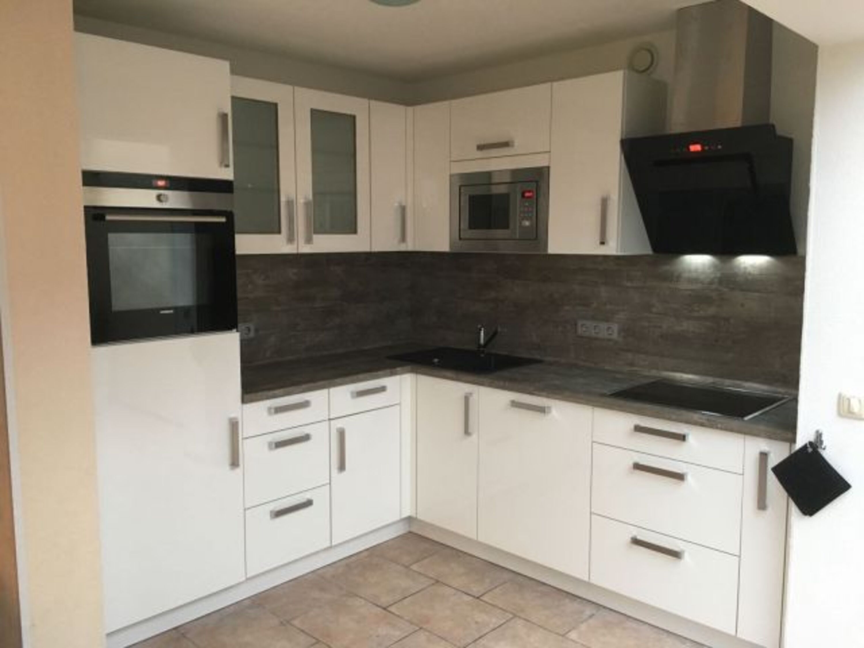 Küche mit Induktionsherd, Geschirrspüler, Mikrowelle, Backofen, Kühlschrank mit Gefrierfach