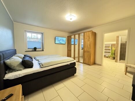 Schlafzimmer mit TV und Zugang zum Bad