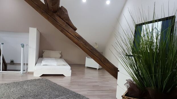 Schlafzimmer im Dachgeschoss mit 6 Einzelbetten, Sofa und TV