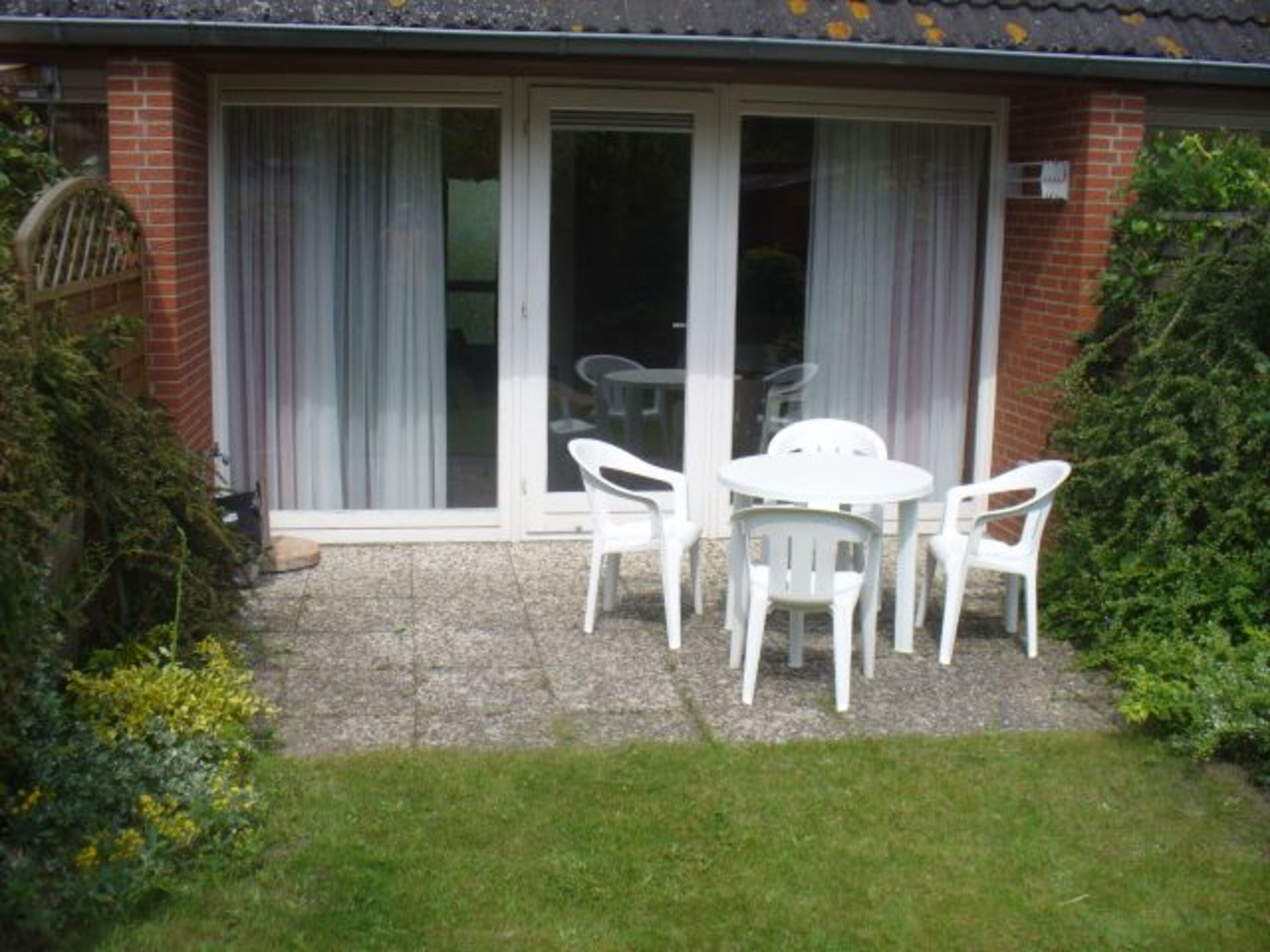 Südterrasse mit kleinem, eingezäunten Garten