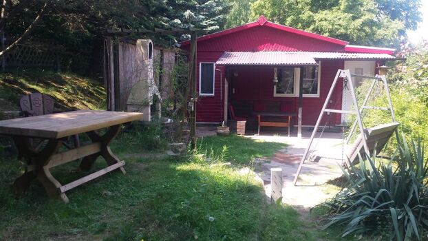 überdachte Terrasse mit Grillkamin und Hollywoodschaukel