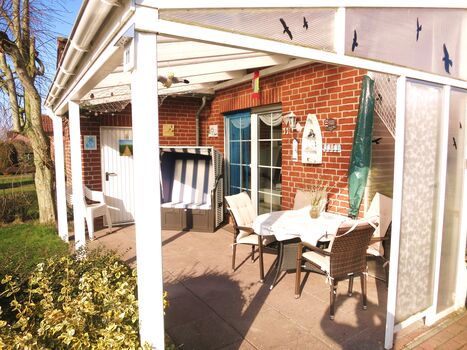 Überdachte Terrasse mit Strandkorb und Möbel