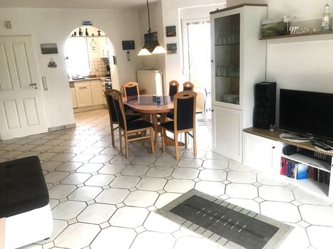 Wohnzimmer 33m² Eingang zur Küche, Essecke mit 6 Stühlen, Erker