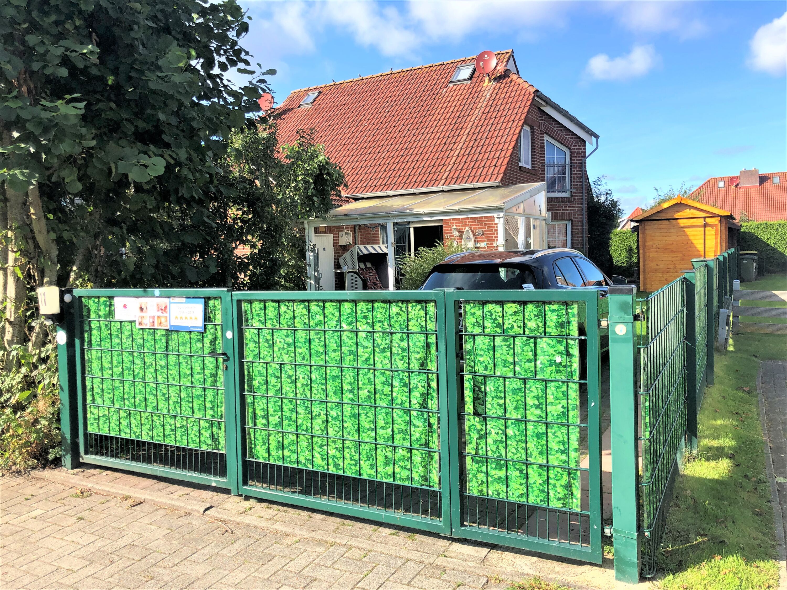 Vorderansicht mit komplett umzäuntem Grundstück