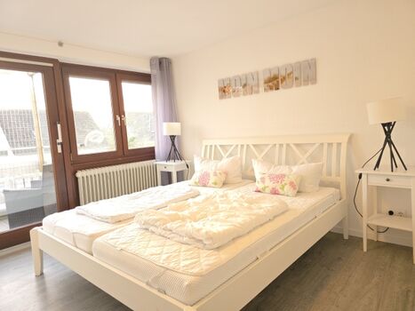 kleines Schlafzimmer mit Doppelbett und TV