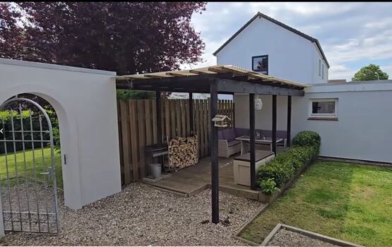 Überdachte Lounge im hoch eingezäunten Garten