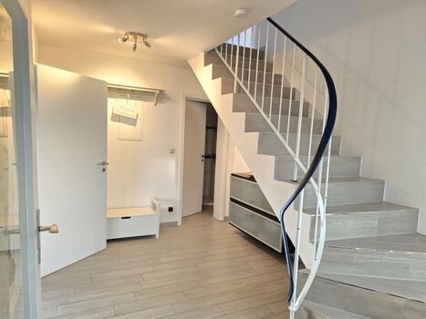 der große Flur mit der geschlossenen, breiten Treppe ins OG