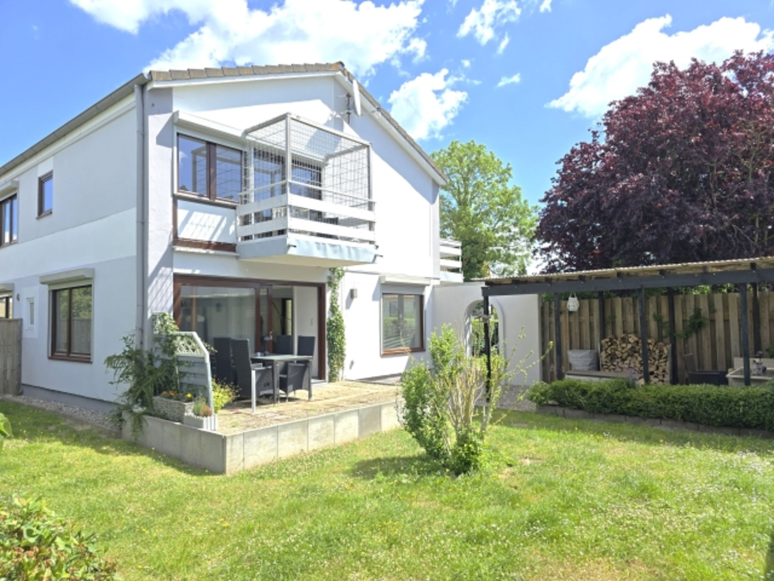 Blick auf das Haus vom Garten aus, dieser ist komplett hoch eingezäunt