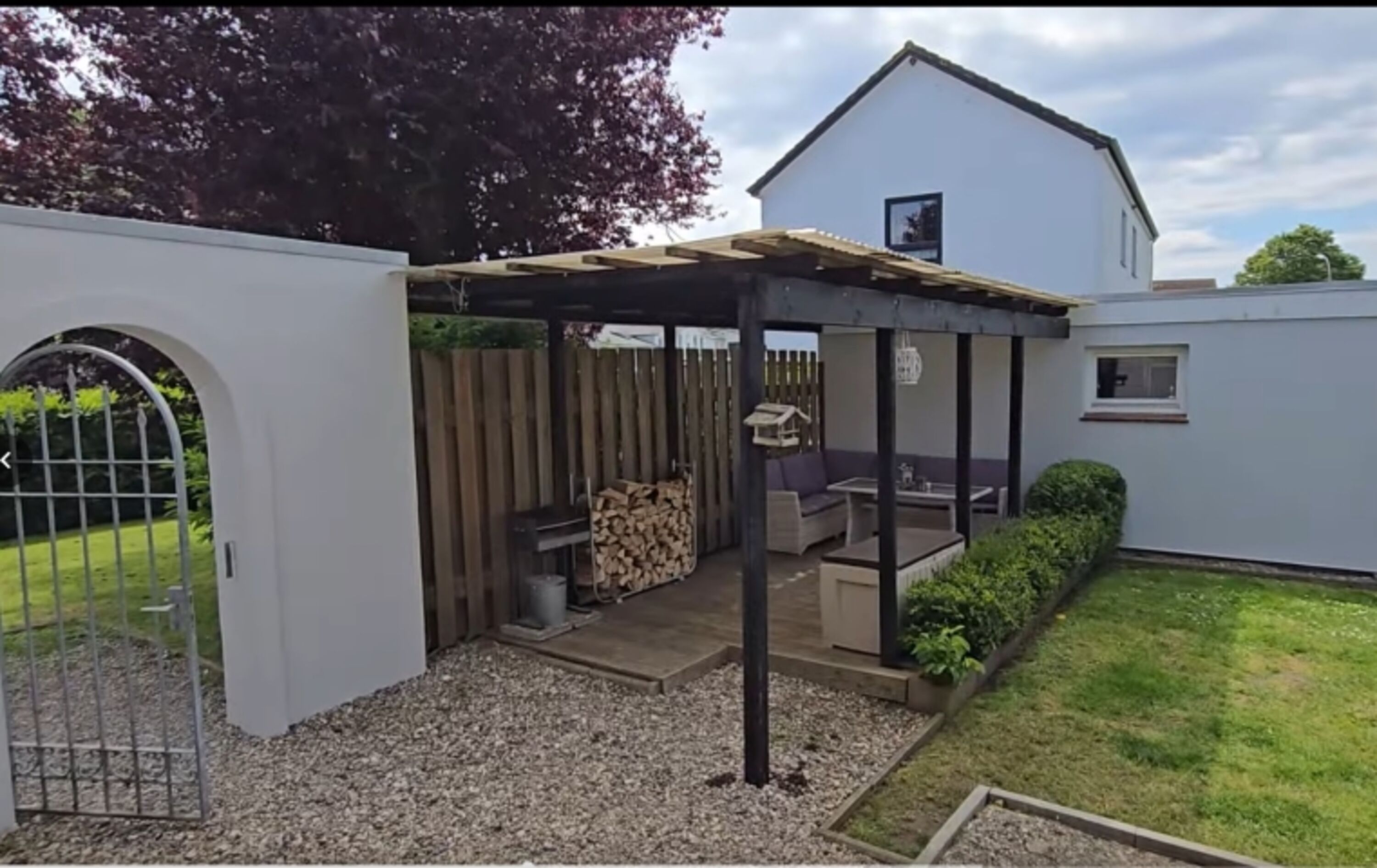 Überdachte Lounge im hoch eingezäunten Garten