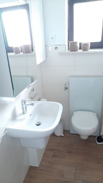 Bad mit Fenster zum Vorgarten und beleuchtetem Spiegelschrank