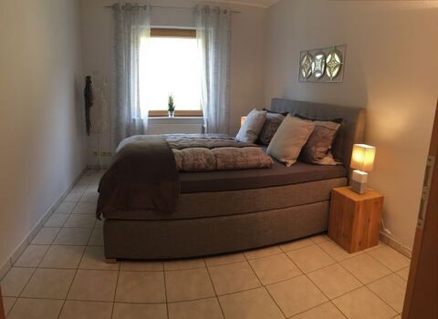 kleines Schlafzimmer mit Boxspringbett und zusätzlichem Flachbildfernseher