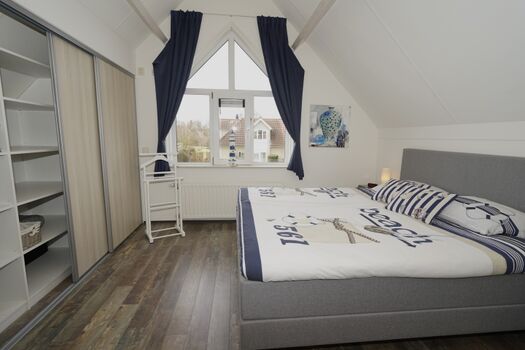 Schlafzimmer 1 mit bequemen Boxspringbett, geräumigem Einbauschrank und Verdunkelungsvorhang