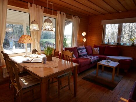 offener Wohn-Essbereich mit großen Fenstern und Blick über die Wiese